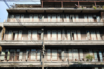 Weathered Apartment Building Facade with Many Windows and Wires in Bangkok