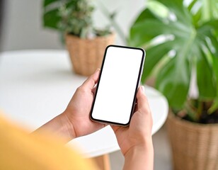 Over shoulder close up view of female hand holding smartphone with mock-up screen