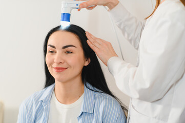 Doctor diagnoses the structure of the hair. Consultation with a trichologist