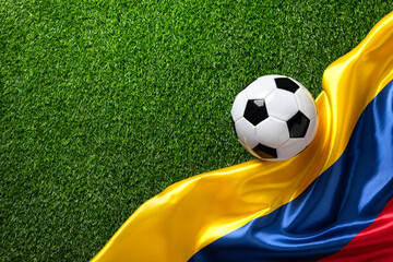 A soccer ball on a green field with a Colombian flag. High quality photo