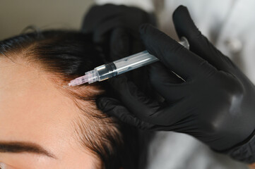 Young woman with hair problem receiving injection in clinic. Hair renewal rejuvenation pampering...