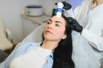 Doctor diagnoses the structure of the hair. Consultation with a trichologist
