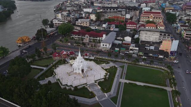 Surat Thani,Thailand-28 Jan 2025: Slow-motion aerial shot of Surat Thani City Pillar Shrine and the city skyline with Tapi River at dusk, Thailand.