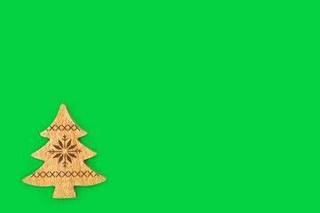 Christmas tree natural wooden decoration background on green. Eco friendly ethical, natural Xmas, Noel, Yule symbol for the festive holiday season. Copy space. 