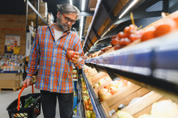 Mature senor in the vegetables section of the supermarket