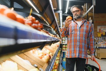 Mature senor in the vegetables section of the supermarket