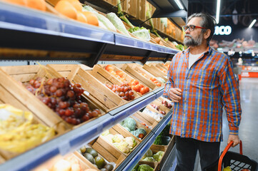 Mature senor in the vegetables section of the supermarket