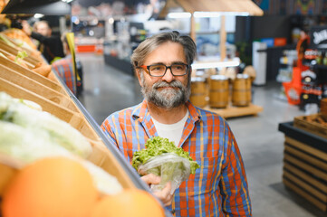 Mature senor in the vegetables section of the supermarket