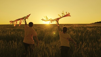 father and son run with kite in hand catching wind n sunset, happy family, boy and dad have fun...