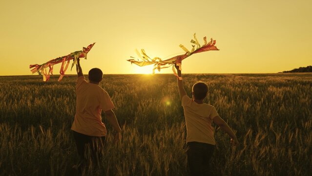 father and son run with kite in hand catching wind n sunset, happy family, boy and dad have fun playing game together in field, travel on weekends, summer vacation in countryside, childhood dream fly
