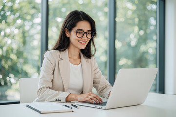 Young woman with glasses working on a laptop office