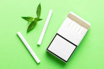 Pack of menthol cigarettes and fresh mint on colored table, Menthol cigarettes top view flat lay