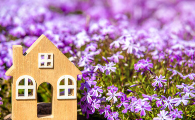 The symbol of the house stands among the purple flower
