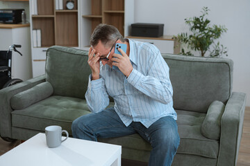 Senior man sitting in sofa, having depression, stress, irritability, and life problems.
