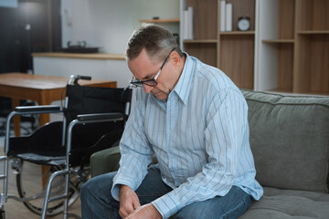 Senior man sitting in sofa, having depression, stress, irritability, and life problems.