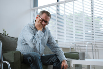 Senior man sitting in sofa, having depression, stress, irritability, and life problems.