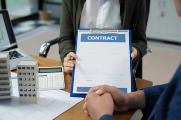 Real estate broker agent presenting and consult to customer to decision making sign insurance form agreement, home model, concerning mortgage loan offer in office
