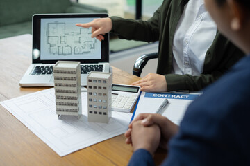 Real estate broker agent presenting and consult to customer to decision making sign insurance form agreement, home model, concerning mortgage loan offer in office
