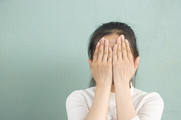 A woman hand covering face in frustration, symbolizing stress or anxiety