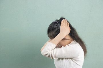 A woman holding her head in frustration, symbolizing stress or anxiety