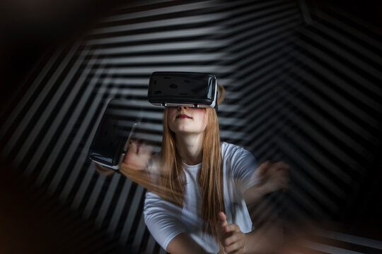 Girl wearing virtual reality headset by striped wall