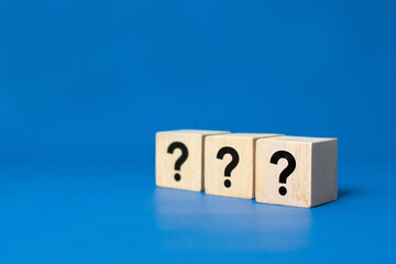 ? Questions Mark word in wooden cube block on table background. FAQ Answer, Q&A