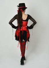 full length portrait burlesque circus performer, female model in halloween jester clown costume...