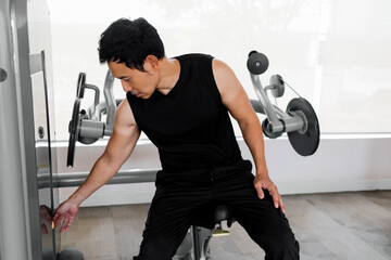 Asian athlete gripping cable in gym during workout preparation