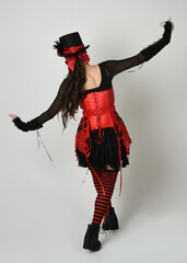 full length portrait burlesque circus performer, female model in halloween jester clown costume...