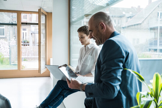 Businesswoman and colleague discussing work in a modern office