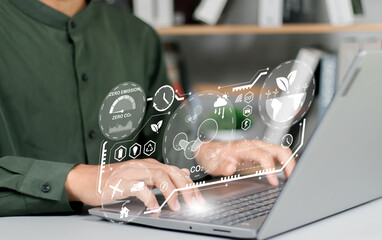 Business man using computer on CO2 emission reduction concept with global warming icon. along with...