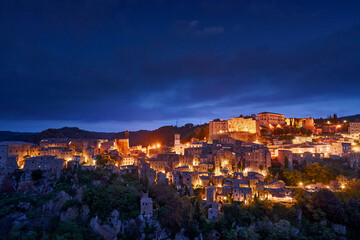 Sorano, Tuscany in Italy. A small medieval town on a cliff. Night city lights. Village in the rock,...