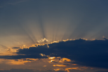 Dark cloud and sun rays at sunset.