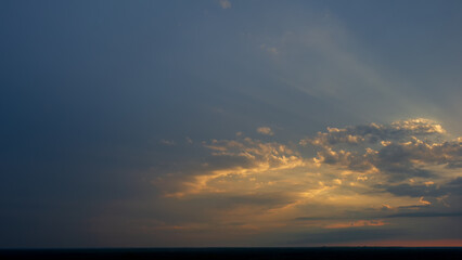 Evening clouds in the sky on the horizon line at sunset.