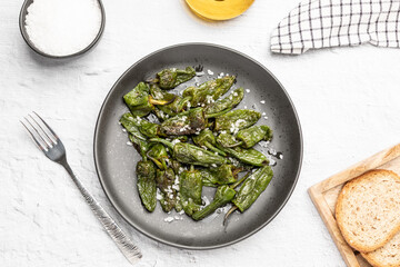 Top view of spanish traditional food grilled green padron pepper with salt