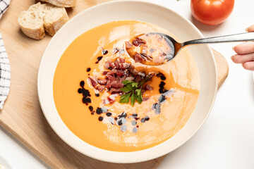 Hand taking a scoup of salmorejo, cold tomato soup, Spanish traditional food.