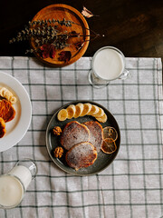 Delicious breakfast featuring pancakes, banana slices, and fresh milk on a cozy table setting