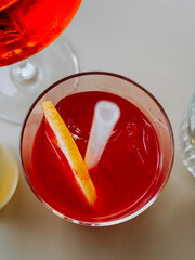Refreshing cocktail served in a glass with a slice of lemon and ice on a table at a bar