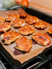 Baked pastries with golden crust on a tray in a cozy kitchen setting during the evening