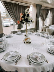 Elegant table setting with floral centerpiece and teddy bear for special occasion