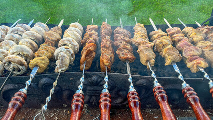 Variety of skewers are being cooked on a grill, with some being cooked to different levels of doneness