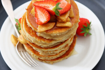 pancakes topped with apple slices and strawberries