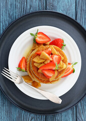 pancakes topped with apple slices and strawberries