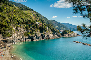 Monterosso al Mare, calm bay with crystal blue water and green terraces on the slopes.