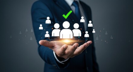 Photo of a businessmans hand displays a glowing group of people icons with a check mark, representing successful teamwork