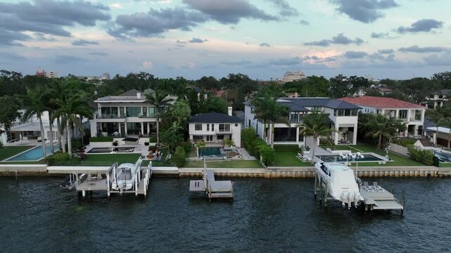 Luxury and exclusive villas with swimming pool and private river access in Tampa, Florida. Aerial lateral wide shot. Private jetty pier in noble district of USA.