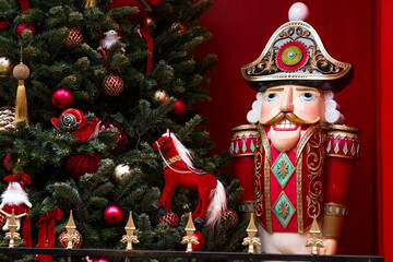 Fototapeta premium The Nutcracker on the New Year's tree in Moscow. New Year's card 2026. Beautiful Christmas background. Concept of preparing decorations and attire for the New Year.
