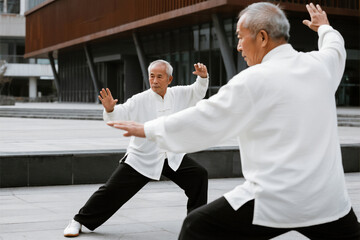 Elderly Asian Men Practicing Tai Chi in City Square