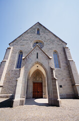 Fototapeta premium Large Stone Church With Wooden Door and Stained Glass Windows