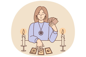 Woman with Tarot cards in form of witch sits at table and predicts future being fortune teller